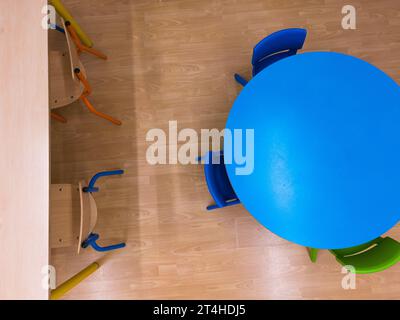 Aerial view of a school classroom, with brown and colored chairs and tables Stock Photo