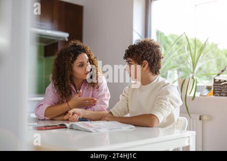Mother helping her son with homework at home Stock Photo