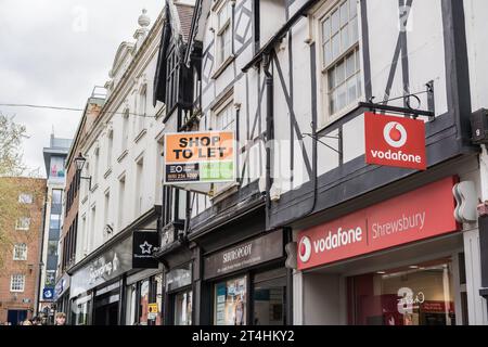 Shrewsbury, Shropshire, England, May 1st 2023. Vodafone mobile phone store with shop for sale sign in background, retail editorial illustration. Stock Photo