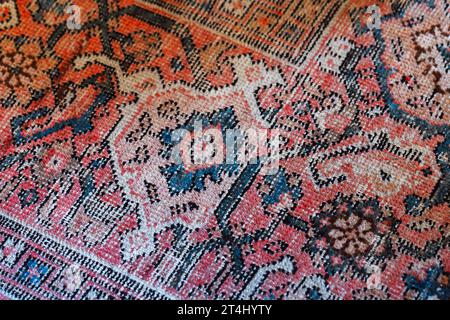 Old oriental woolen carpet with traditional colorful floral ornament. Close up photo background Stock Photo