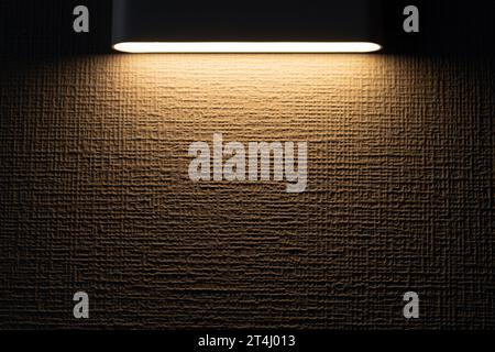 White spot of light is on textured yellow wall, background photo texture, front view with copy space area Stock Photo