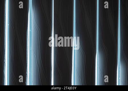 Vertical blackout blinds mounted on a window with bright sunlight outside Stock Photo