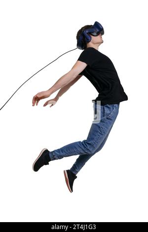 Excited young male in VR glasses flying through spase. Using VR headset, white background. Concept of the future is here Stock Photo