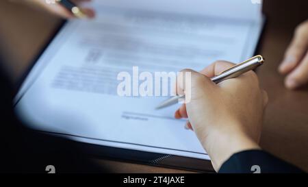 Hands of lawyer pointing at paper for businessperson signing contract. Solicitor, legal advisor helping mature client to fill up document Stock Photo
