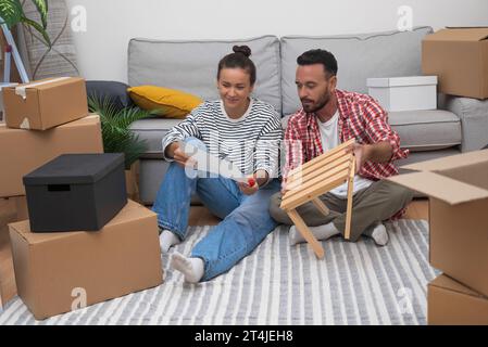 Couple in love looks at instructions for assembling furniture Stock Photo