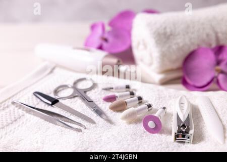 manicure pedicure tools set. closeup of nail drill bits with other nail care accessories on white towel. beauty treatment Stock Photo