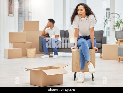 When things dont go right, go left. a young woman looking worried while unpacking boxes in her new house. Stock Photo