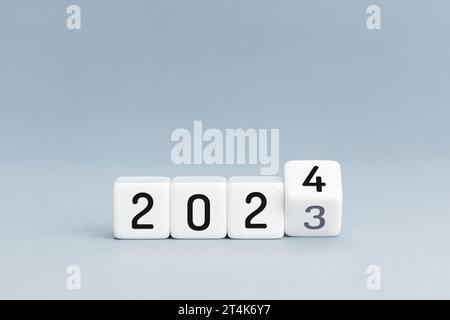 New Year concept. Change from 2023 to 2024 cube blocks isolated on blue background. Copy space Stock Photo