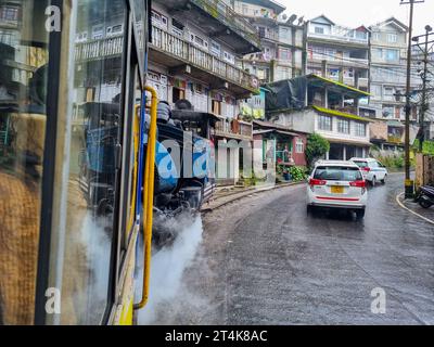 view outside toy train in darjeeling shimla showing the wet street and cars moving on the road showing this famous attraction Stock Photo