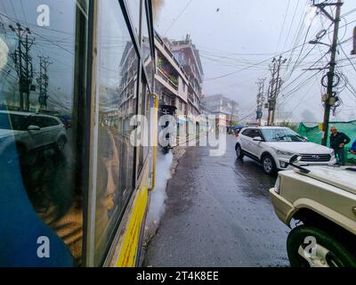 view outside toy train in darjeeling shimla showing the wet street and cars moving on the road showing this famous attraction Stock Photo