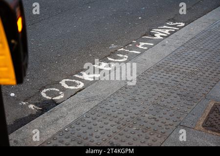 'Look Both Ways' letters are painted on the New Oxford Street. Pedestrian crossing in the London Borough of Camden, UK. Stock Photo