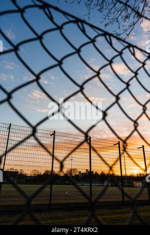 wire mesh fence in front of sunset sky Stock Photo