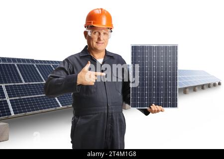 Technician in a uniform holding a photovoltaic panel at a solar farm and pointing isolated on white background Stock Photo