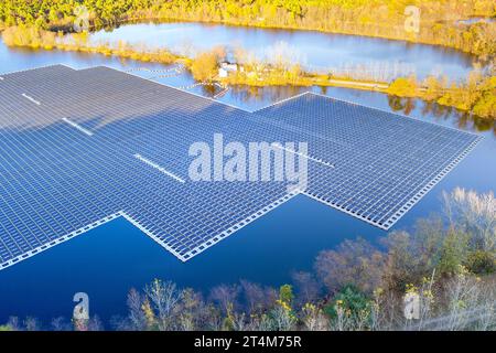 Pond with floating solar panels that generate electricity from sun by using sunlight to produce electricity Stock Photo