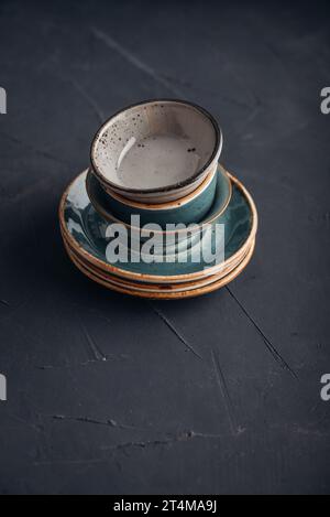 Stack of plates and bowls on black background  closeup Stock Photo