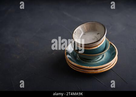 Stack of plates and bowls on black background  closeup Stock Photo