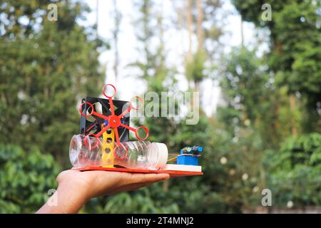 Soap bubble blowing machine built at home using some electronics held in the hand outdoors Stock Photo