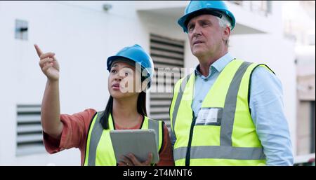 Construction, team and tablet for inspection with people at job site, mentor and apprentice with communication. Architecture, engineering and digital Stock Photo