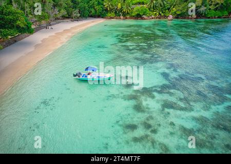 Drone of baie lazare beach,  docking fisherman boat on low tide near  the shore, turquoise water, sunny day, Mahe Seychelles Stock Photo