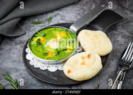 creamy broccoli soup in a frying pan with tortillas against a dark background, side view Stock Photo