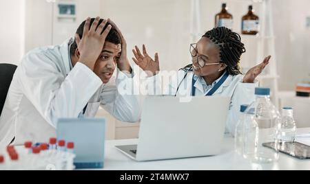 Could this be it. two scientists looking surprised while working together on a laptop in a lab. Stock Photo