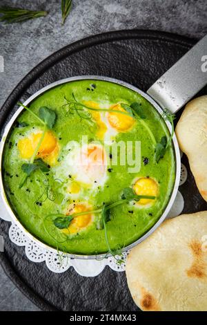 creamy broccoli soup in a frying pan with tortillas against a dark background, top view Stock Photo