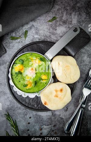 creamy broccoli soup in a frying pan with tortillas against a dark background, top view Stock Photo