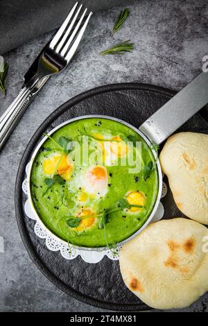 creamy broccoli soup in a frying pan with tortillas against a dark background, top view Stock Photo