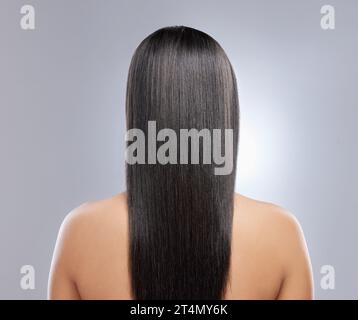 Her hair is healthy and beautiful. Rearview shot of a woman with long brown hair. Stock Photo