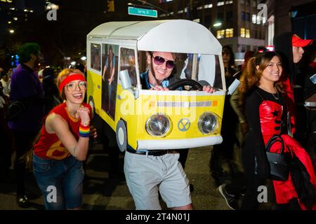 New York City, NY, USA. 31st Oct, 2023. The annual Greenwich Village Halloween Parade drew crowds of costumed participants along with bands, dance troupes, stilt walkers, commercial floats, and giant puppets. A couple with a VW bus dressed as hippies from the 1970s. Credit: Ed Lefkowicz/Alamy Live News Stock Photo