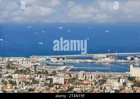Haifa, Israel - October 22, 2023: Seaport in the city of Haifa, panorama of the port and city buildings against the background of a blue sky with clou Stock Photo