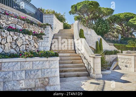 Stone staircase with stone walls and greenery against the blue sky Stock Photo