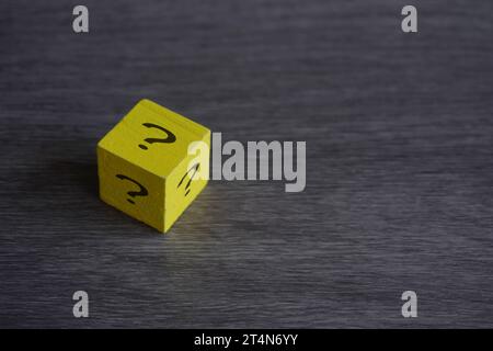 Wooden cube with question mark on table with copy space. Concept of luck, risk and choice. Stock Photo