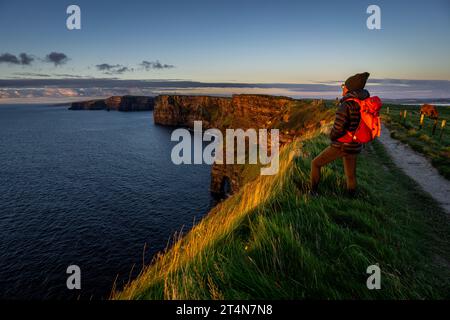 Cliffs of Moher, cliffside hiker, The Burren, County Clare, Ireland, United Kingdom Stock Photo