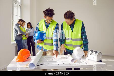 Engineers and architects discussing for plans for new home and working on a building site Stock Photo
