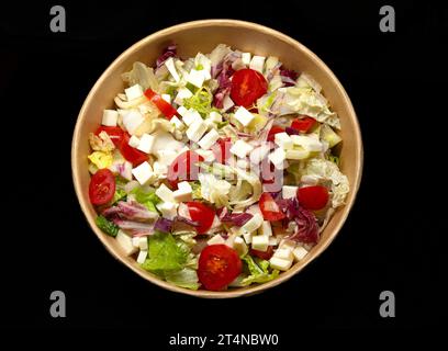 vegetable salad with cheese in a bowl on black background. Stock Photo