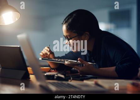 She doesn’t give up until it gets fixed. a young technician using a screwdriver to repair computer hardware. Stock Photo
