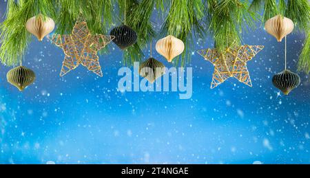 Christmas or New Year festive composition. Fir branches , gold Christmas decorations and paper balls over empty wooden table. Stock Photo