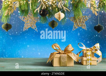 Christmas or New Year festive composition. Fir branches, gold Christmas decorations and gift boxes on wooden table. Stock Photo