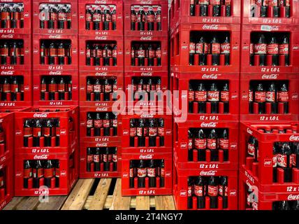 Display of in wholesale on pallet wooden pallet side by side one above the other stacked high red boxes con Coca Cola each with 12 twelve 1 litre Stock Photo