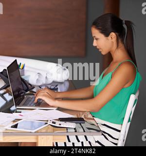 Shes dedicated to her business. a young woman working on her laptop in her home office. Stock Photo