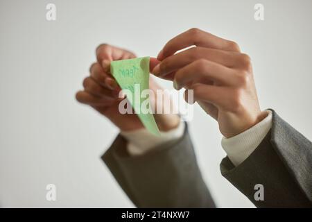 To get to the goal, stick to the plan. an unrecognisable businessman sticking a note to a glass screen in a modern office. Stock Photo