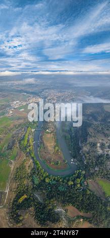 Vertical panoramic and aerial view of the meander of the Ter River as it passes through Roda de Ter on a foggy morning (Osona, Barcelona, Spain) Stock Photo