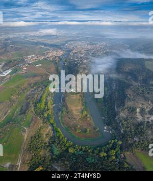 Vertical panoramic and aerial view of the meander of the Ter River as it passes through Roda de Ter on a foggy morning (Osona, Barcelona, Spain) Stock Photo