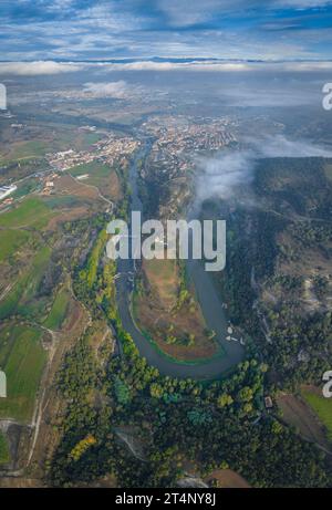 Vertical panoramic and aerial view of the meander of the Ter River as it passes through Roda de Ter on a foggy morning (Osona, Barcelona, Spain) Stock Photo