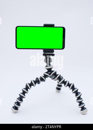 smartphone with green screen on tripod holder. smartphone mock up with chroma key Stock Photo