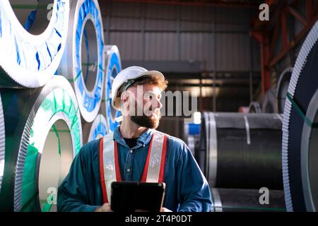 Blue collar worker work at metal sheet factory. Blue collar worker and industry concept. Stock Photo