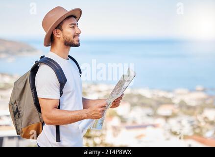 Ill find my way to the next adventure. a young man holding a map while exploring outdoors. Stock Photo
