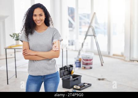 This room will look a little different in a bit. a woman standing in a room under renovations. Stock Photo