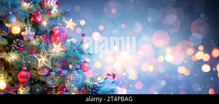 Christmas Tree With Ornaments In Blue - Baubles Hanging On Fir Branches With Glittering And Bokeh Lights In Abstract Defocused Background Stock Photo